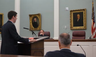 Assistant Attorney General Frank Fredericks argues the state's case to the state Supreme Court on Thursday. Justice Robert Lynn is pictured and at right is Tom Reid.