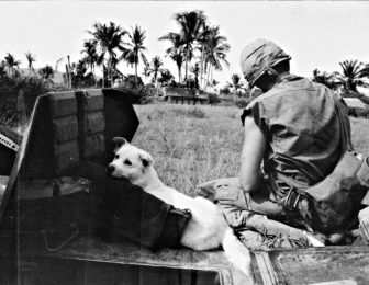 A boy and his dog with an armored cavalry troop during the invasion of Cambodia in May 1970.