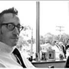 Michael Davidow in black and white in front of a window